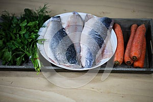 Sea bass filet with ingredients on wooden board