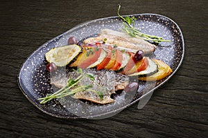 Sea bass fillet with vegetables ratatouille . On dark background, isolated