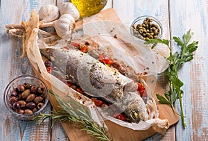 sea bass in foil with black olives tomatoes