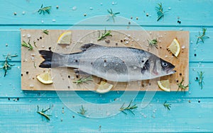 Sea bass on kitchen table on blue wooden background. Top view.