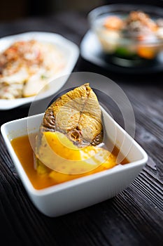 Sea bass in Tamarind Flavor Sour Soup Southern Thai Recipe with pineapple , thai food and vegetable in white bowl
