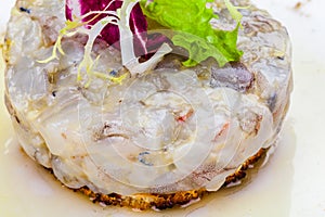 Sea bass tartare with toasted bread on a white plate