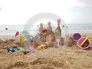 Sea beach castle of sand made by children with toys on it by t