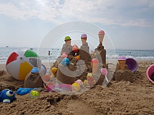 Sea beach castle of sand made by children with toys on it by t