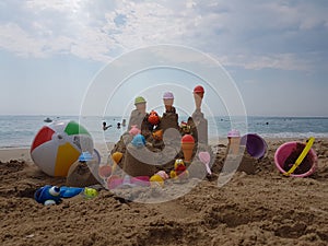 Sea beach castle of sand made by children with toys on it by t