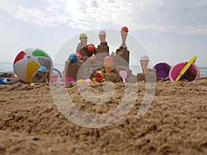 Sea beach castle of sand made by children with toys on it by t