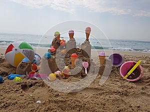 Sea beach castle of sand made by children with toys on it by t