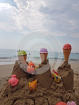 Sea beach castle of sand made by children with toys on it by t