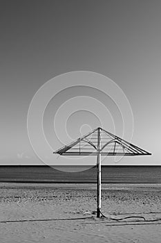 Sea beach with old parasol at off-season