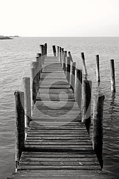 By the sea, beautiful view of a wooden pier, black and white photography. Wooden pier leading to the sea ocean or lake,boardwalk.