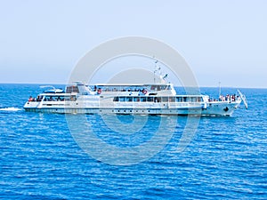 The sea is blue. An old boat is transporting people