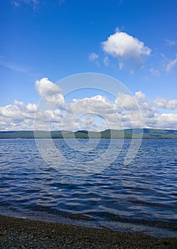 Sea and blue sky. White clouds over lake. Summer Landscape