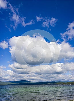 Sea and blue sky. White clouds over lake. Summer Landscape