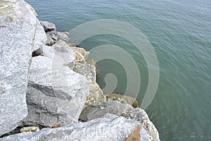 The sea is bordered by large breakwater rocks