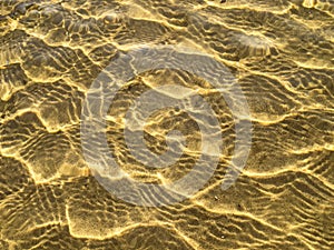 Sea bottom texture, yellow sand waves in shallow water.