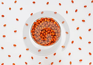 Sea buckthorn berries in bowl on white background. Top view. Selective focus. Orange berries of Hippophae plant. Real photo