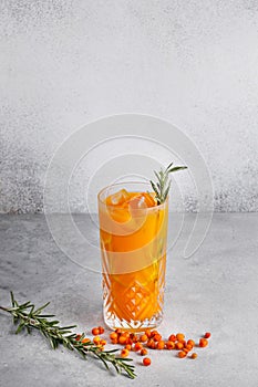 Sea buckthorn lemonade on a grey concrete stand in a glass glass