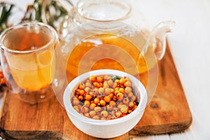 sea buckthorn tea in a clear glass teapot, a natural elixir.