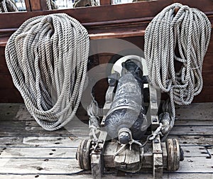 The sea cannon. The old ship cannon, the ropes at the side of the ship. A pirate ship. photo