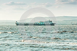 Sea cargo ferry. Mountanious background.