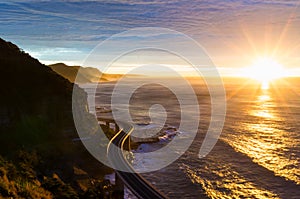 Sea cliff bridge along Australian Pacific ocean coast on sunrise