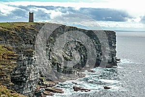 Sea cliffs with medieval tower in Orkeny Scotland