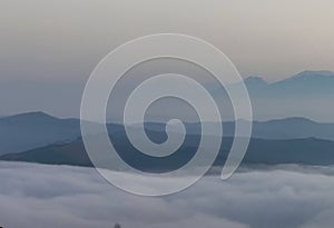 A sea of clouds and fog fills the valleys of the Apennine mountains at sunset