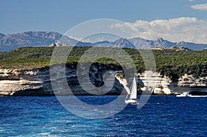 A sea coast in Corsica, Corse, France Europe with cliffs and sailing boat