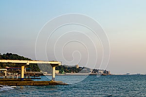 Sea coast with infrastructure: pier, breakwaters, moorings, buildings