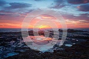 Sea coast sunrise and rock pool reflections