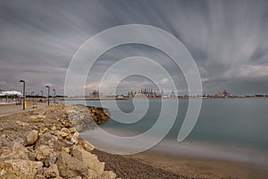 Sea and commercial port with cranes, ultra long exposure in Valencia photo