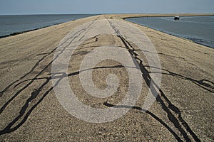 Sea dike at harbor of Harlingen. Repair with tar to fill the cracks