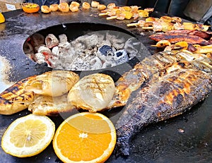 Sea fish, squid and other seafood fried on the grill on the open veranda of the restaurant in Riga