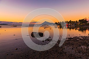 Sea with fishing boats and town at sunset time in Mauritius