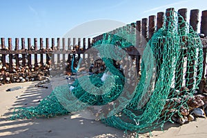 Sea fishing net washed up on the beach. Ocean pollution.