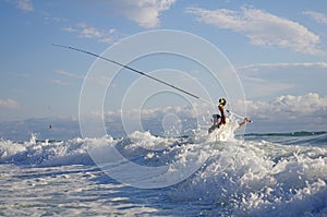 Sea Fishing, surf fishing scene, man fight against the waves