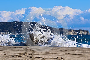 Sea foam created by waves surging on sand and creating amazing texture and patterns.