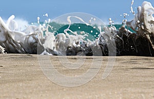 Sea foam created by waves surging on sand and creating amazing texture and patterns.