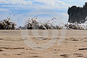 Sea foam created by waves surging on sand and creating amazing texture and patterns.