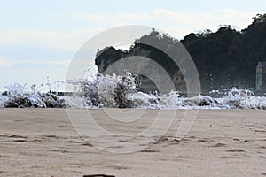 Sea foam created by waves surging on sand and creating amazing texture and patterns.