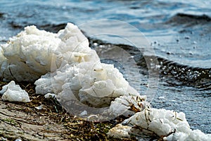 Sea foam forming on the shore of a beach