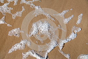 Sea foam in the sand
