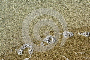 Il mare schiuma sul sabbia 