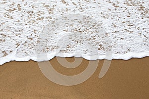 Sea foam on a sandy beach