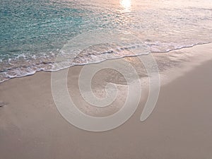Sea foam with a wave on a sandy beach