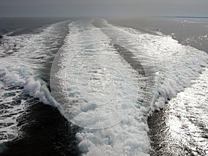 Sea foam waves in perspective behind a ship or boat