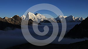 Sea of fog in the Gokyo Valley and sun lit high mountains