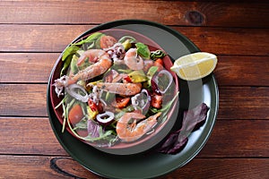 Sea food salad with shrimps, avocado, cherry tomatoes, red hot chilly pepper, red onion, arugula, beet leaves,