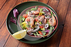 Sea food salad with shrimps, avocado, cherry tomatoes, red hot chilly pepper, red onion, arugula, beet leaves,