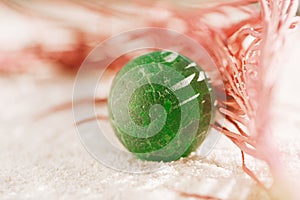 Sea glass marble with red corall  on white sand beach